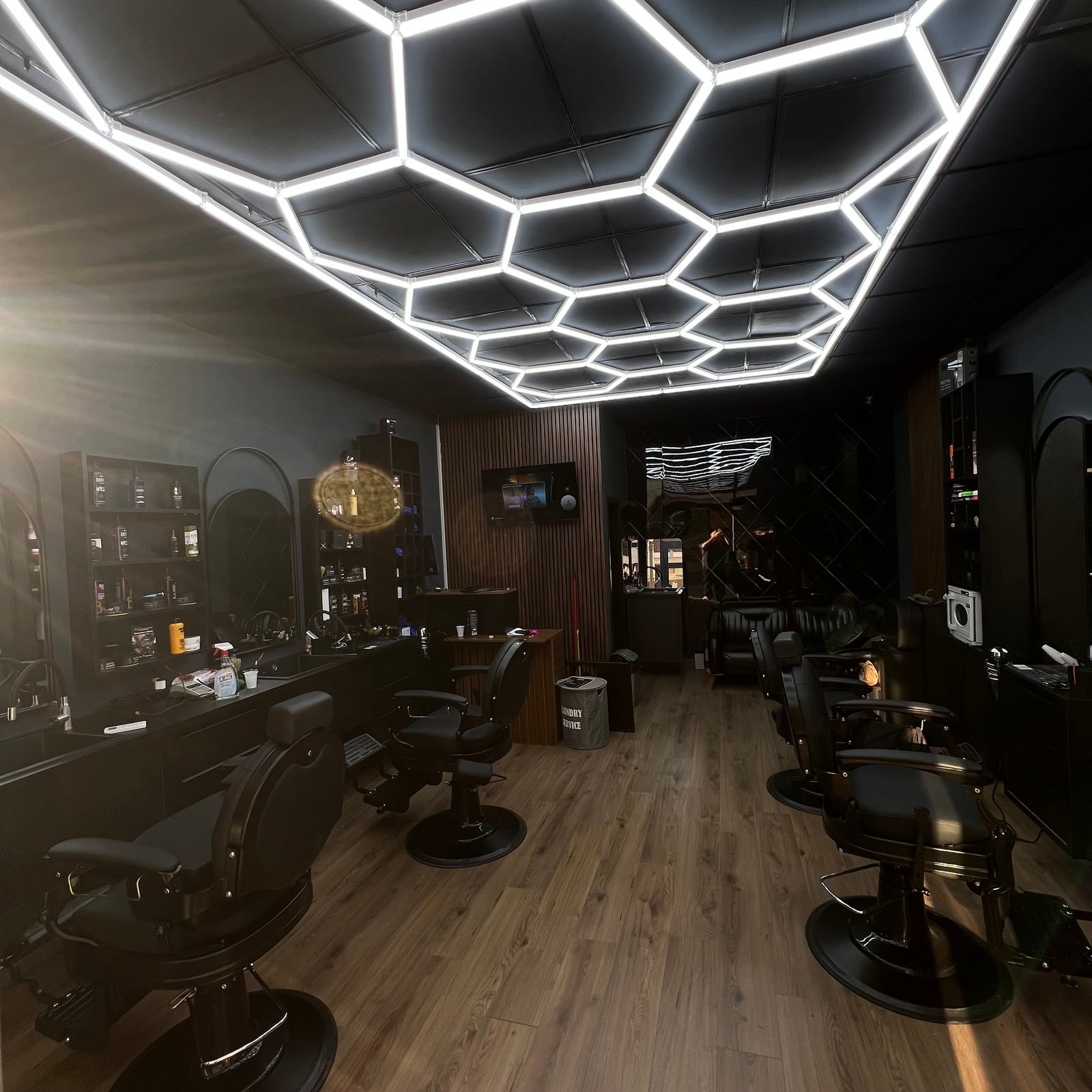 Clip’s Barber Shop Ferizaj – modern barbershop interior with hexagon lights
